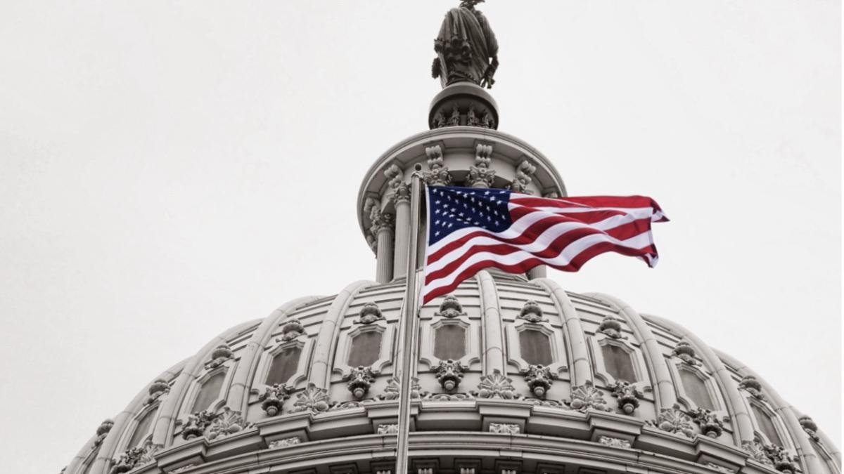 The United States of America flag flying infront of the Capitol Building.