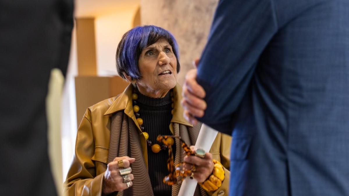 Representative Rosa DeLauro is captured mid-conversation her face shows intense emotion and determination.
