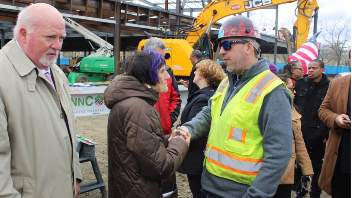 Representative Rosa DeLauro shaking the hand of a construction worker at a construction site.