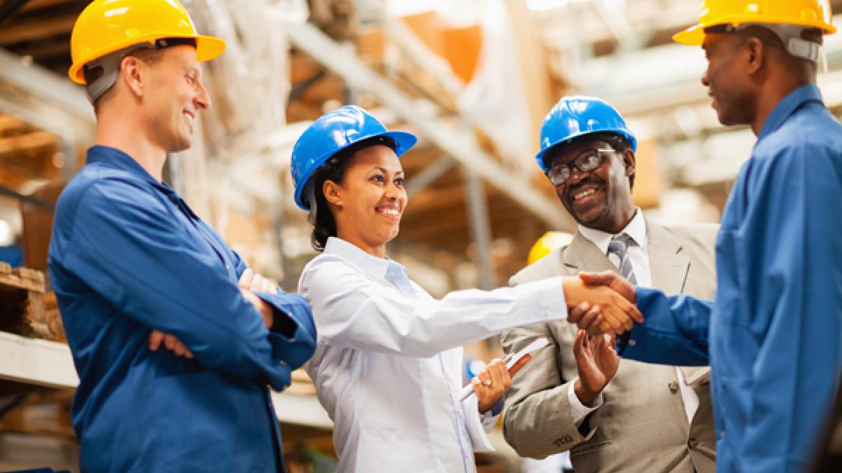 warehouse manager shaking hands with warehouse worker